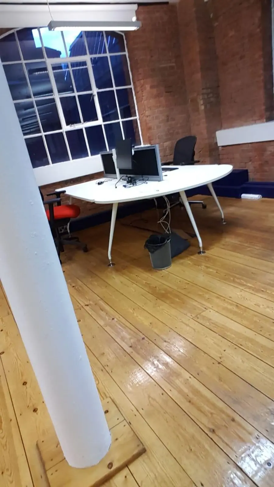Clean London office workspace with exposed brick and desks after a professional autumn deep clean